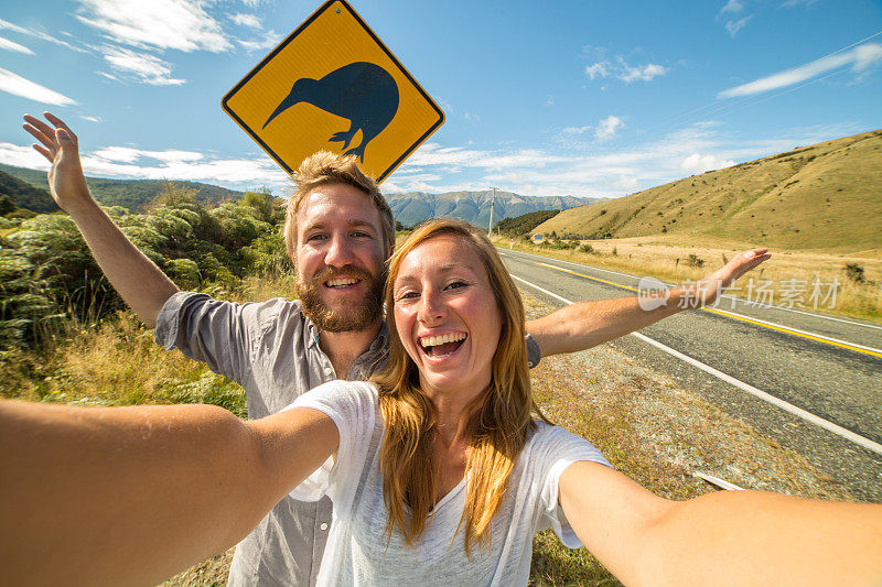 年轻夫妇旅行自拍与新西兰标志