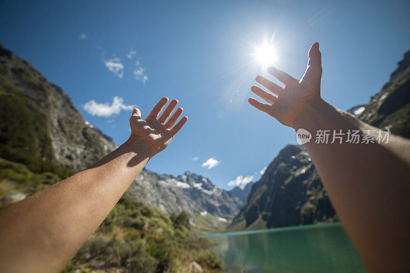 个人视角的女人的双臂伸向山湖