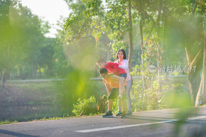 家庭运动快乐活跃的母亲和孩子在户外慢跑，在森林里跑步