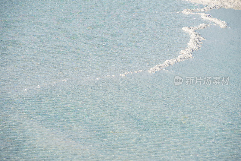 盐晶体从咸涩的蓝色水中伸出来。