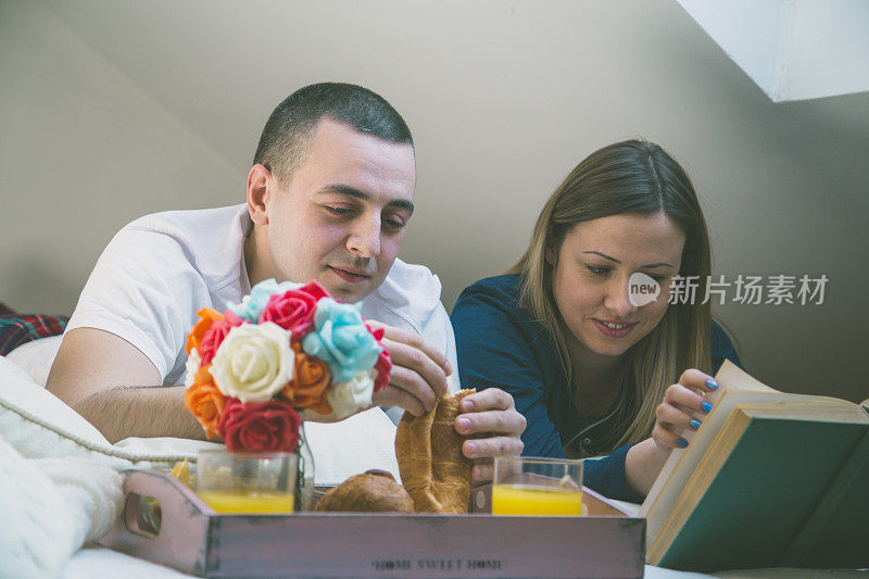 浪漫的夫妇在床上吃早餐