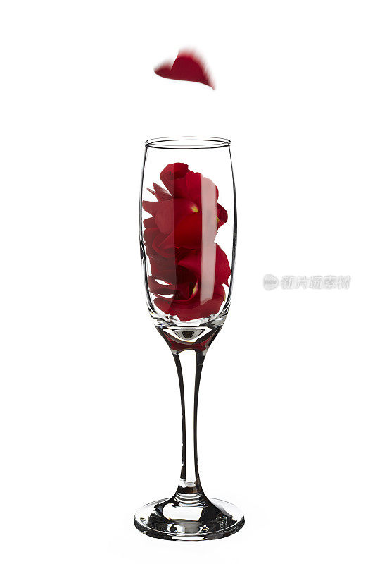 红色玫瑰花瓣内的香槟杯与下降的心形