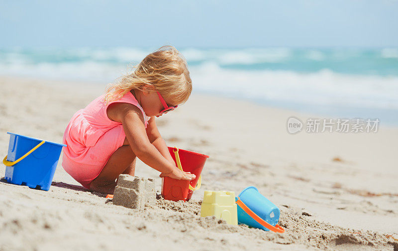 可爱的小女孩在沙滩上玩沙子
