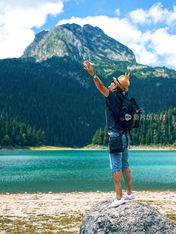 男人站在山上伸开双臂