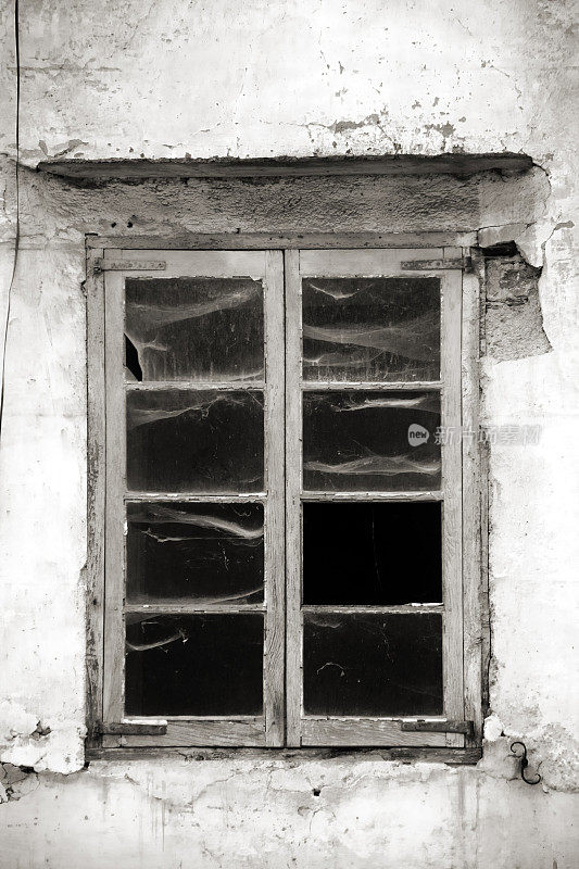 传统的石头房子，黑色和白色的旧窗户关闭。