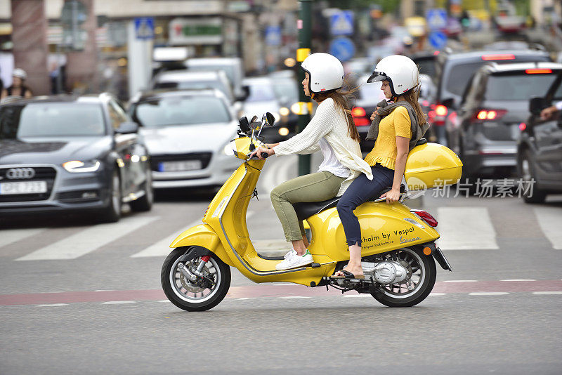 在斯德哥尔摩市中心，两名女子骑着黄蜂