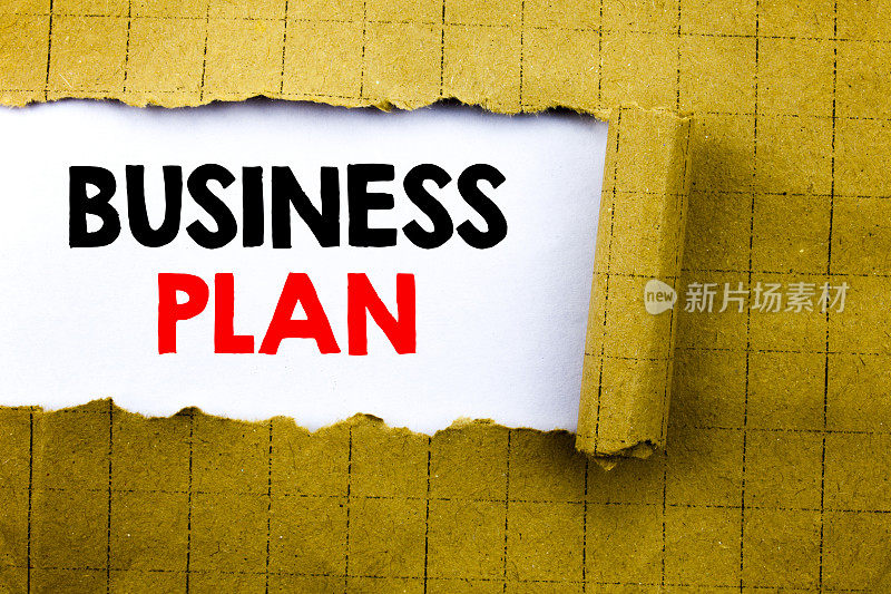 字，写计划书计划书。准备项目战略的商业概念写在黄色折叠纸上的白纸上。