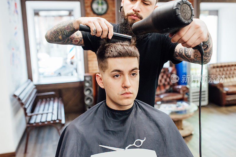 在理发店里剪时髦发型的男人。