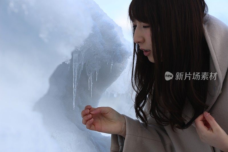 一个年轻女子从堆积的雪中出现