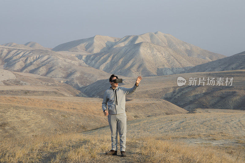 带着3D眼镜独自在极端地形中行走的年轻人