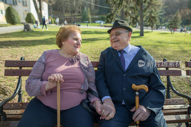 一对老夫妇坐在温泉公园的长椅上。结婚60周年纪念日