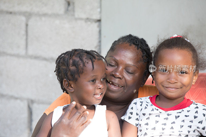 来自偏远村庄的牙买加母亲抱着她的两个小女儿