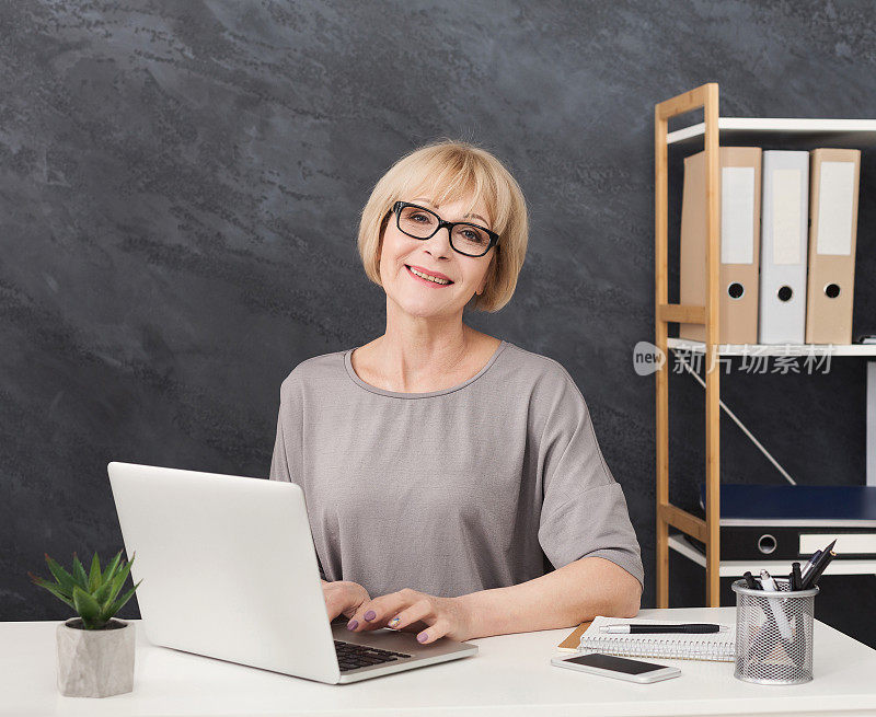 职业女性行政经理，在办公室使用笔记本电脑工作