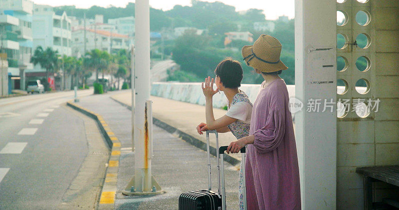 两个女人在等公共汽车。