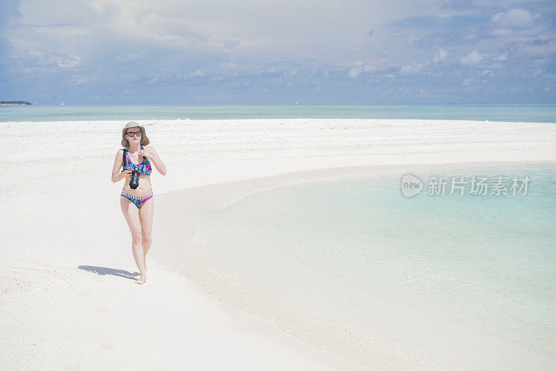 4月，马尔代夫，游客，老妇人拿着相机走在离Maafushi岛不远的沙洲上