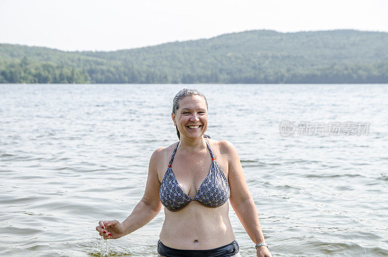 在酷暑夏日，一名女子从湖水中走出来