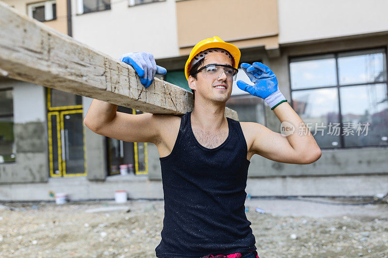 建筑工人在工地搬运木板的肖像