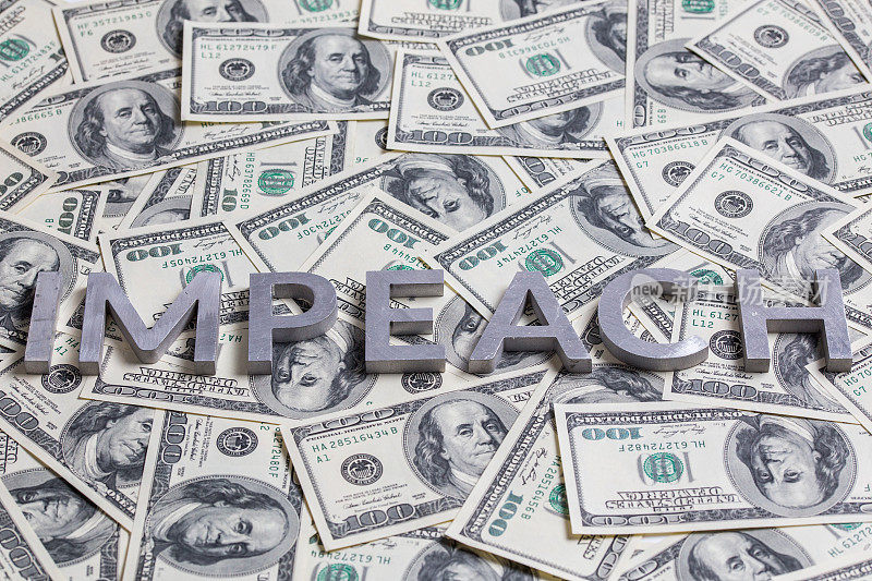 “弹劾”一词以铝制字母出现在美元钞票的背景上——有选择性地聚焦