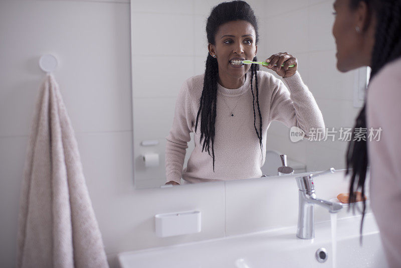 爱护牙齿健康的妇女，用牙刷清洁牙齿。