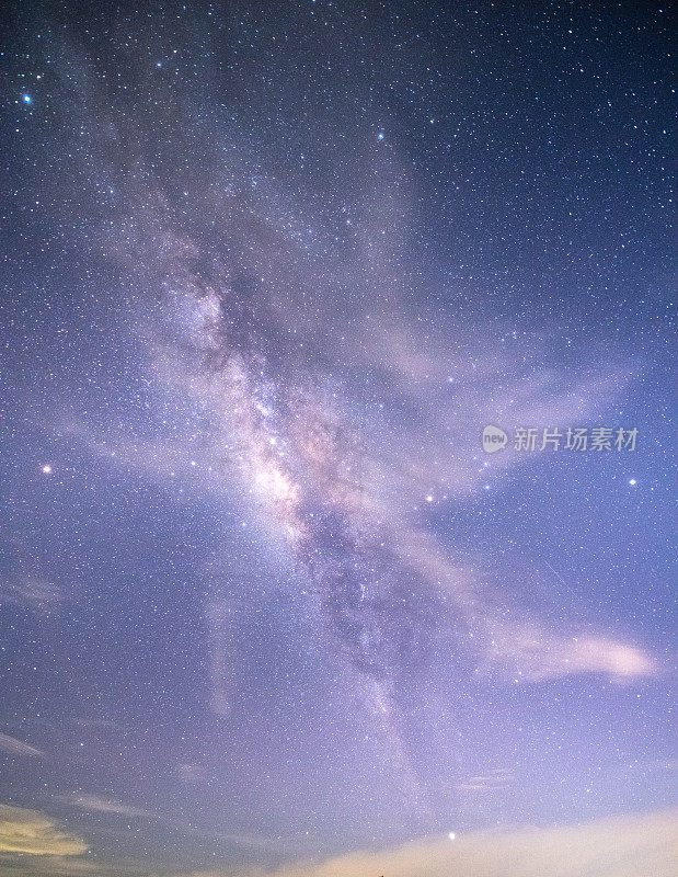 山上有银河和粉红的光。晚上多彩的景观。夏天的星空和山峦。美丽的宇宙。太空背景与星系。旅游的背景