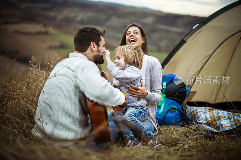 爱玩的家庭有乐趣的露营在秋天的一天在自然。