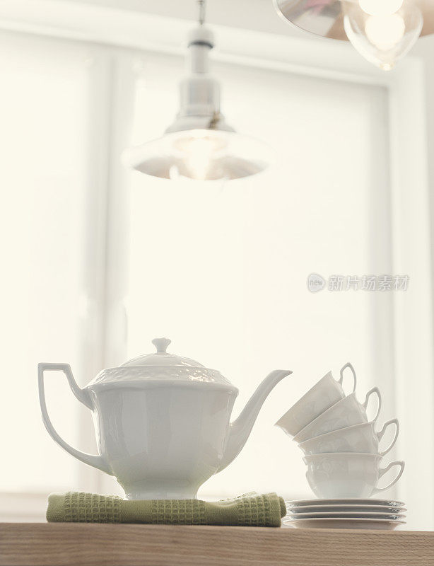 白色优雅的茶壶，木桌上有сups