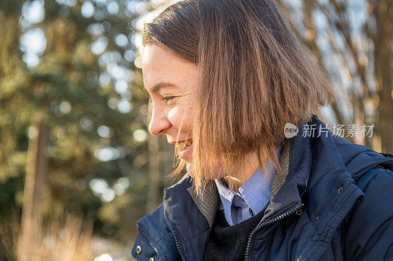 一个千禧妇女的肖像在一个阳光明媚的冬日户外，欧洲