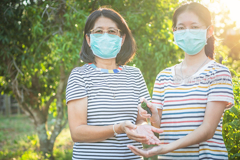 年轻的亚洲妇女戴着防护口罩，以防止全球突发卫生事件Covid-19的传播