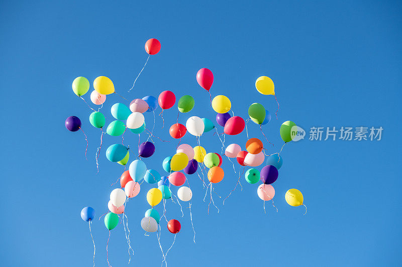 五颜六色的气球迎着蓝天飞翔