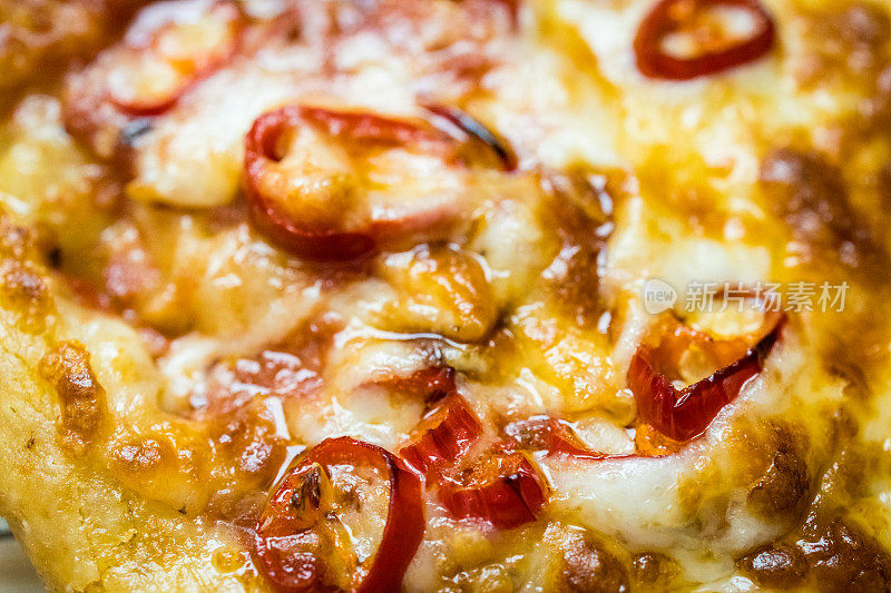 近距离的图像，新鲜出炉的披萨与红辣椒
