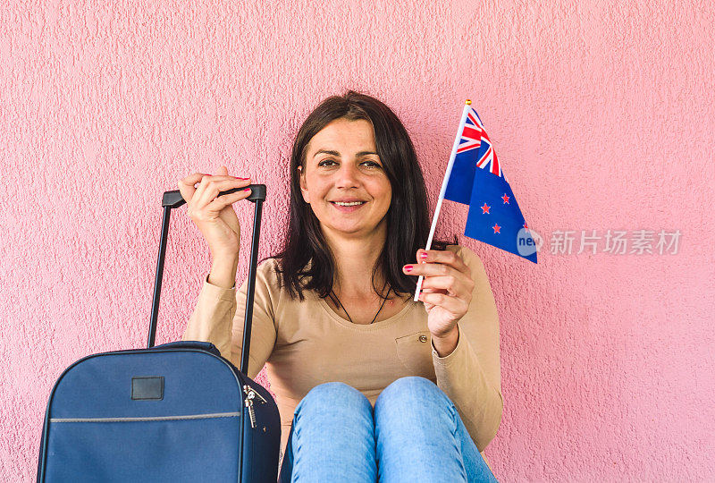 拿着旅行袋和新西兰国旗的女人