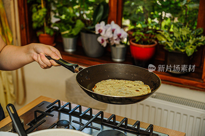 女人在煎锅里准备煎饼的特写镜头。