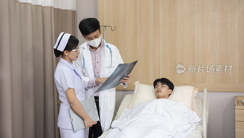 医生与护士在医院检查老年临终关怀病人的x光片结果。