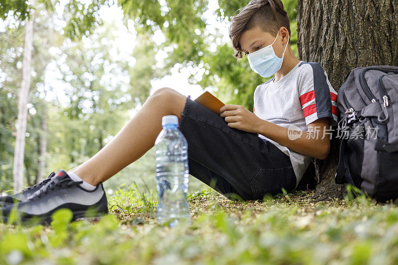 戴着面具在大自然中学习的男孩