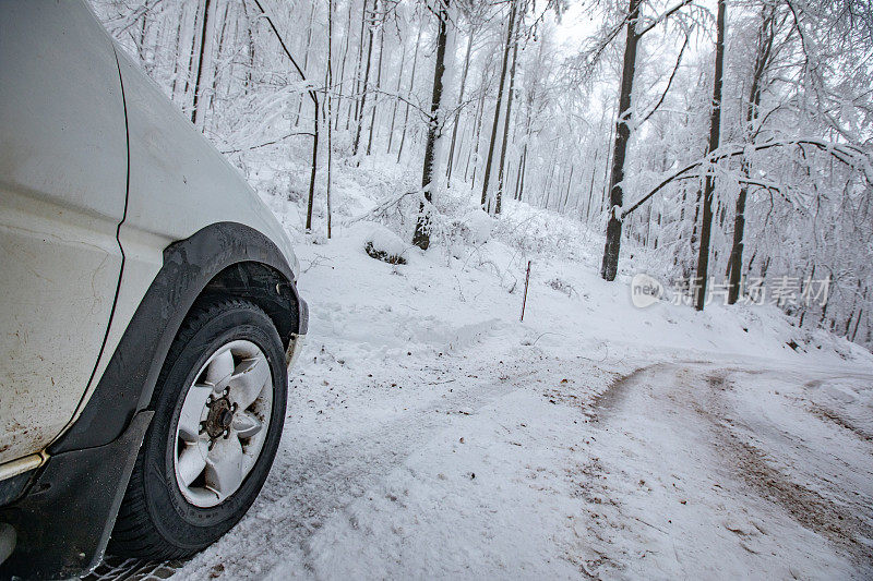 在被雪覆盖的滑土路上行驶的越野车