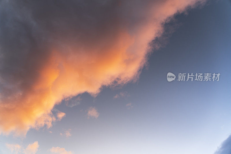 夕阳下的天空，有着引人注目的橙色云彩。大自然天空的云彩背景。