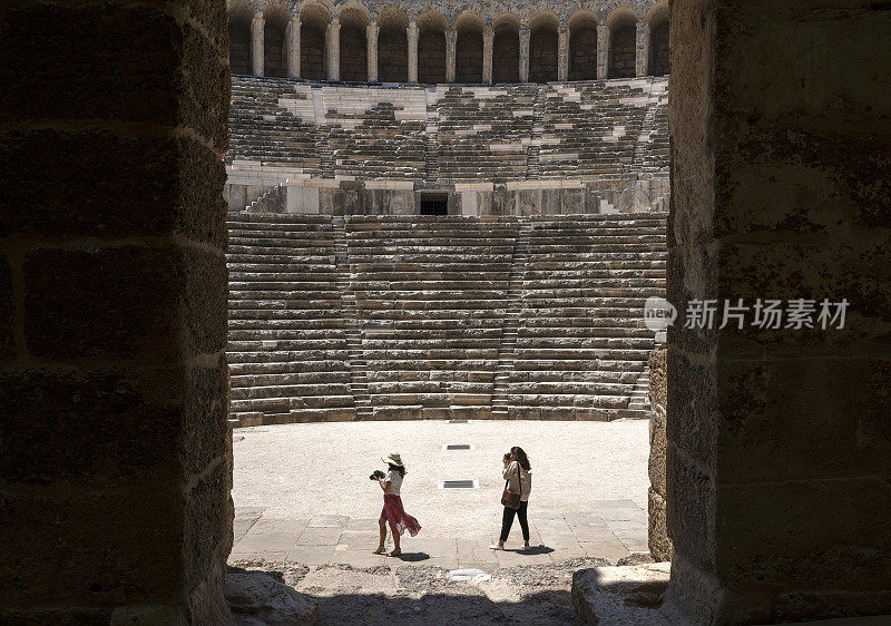 男女游客摄影师在土耳其安塔利亚的阿斯彭多斯圆形剧场拍照