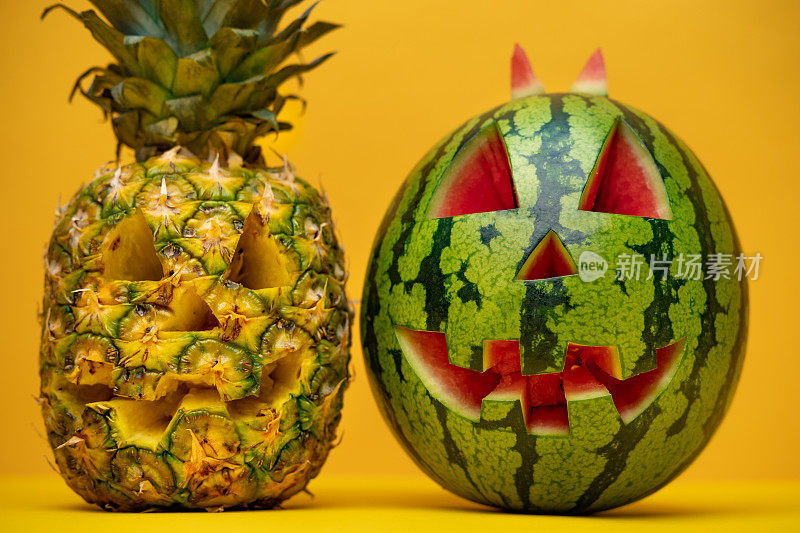 热带南瓜灯西瓜和菠萝万圣节装饰橙色背景。