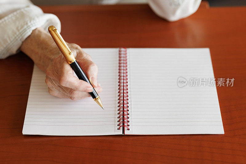 女人用笔在纸上写字的笔迹