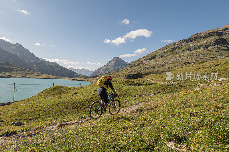 山地自行车手沿着高山湖泊骑行