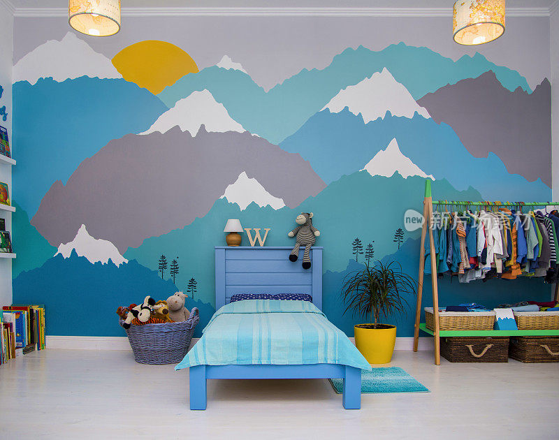 男孩卧室有一幅美丽的青绿色和灰色的山墙壁画。室内设计