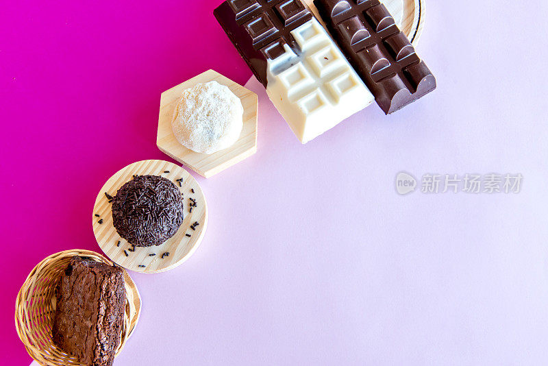 粉色背景的Brigadeiro糖果，布朗尼和巧克力棒。前视图。