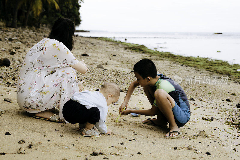 母子俩在沙滩上玩沙