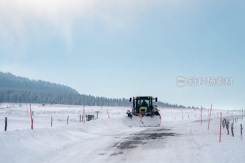 一辆扫雪机正在清扫一条小路上的积雪