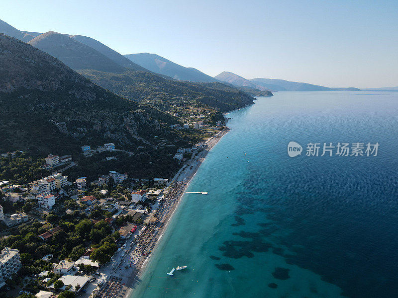 无人机拍摄的阿尔巴尼亚爱奥尼亚海岸的夏季海滩度假胜地的雨伞，罗施