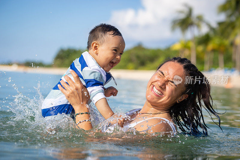 妈妈和儿子在海滩上玩得很开心。