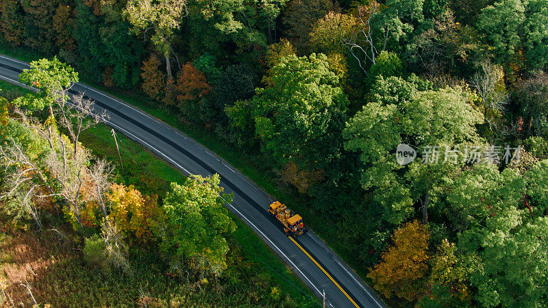 鸟瞰图，卡车在纽约乡村粉刷道路