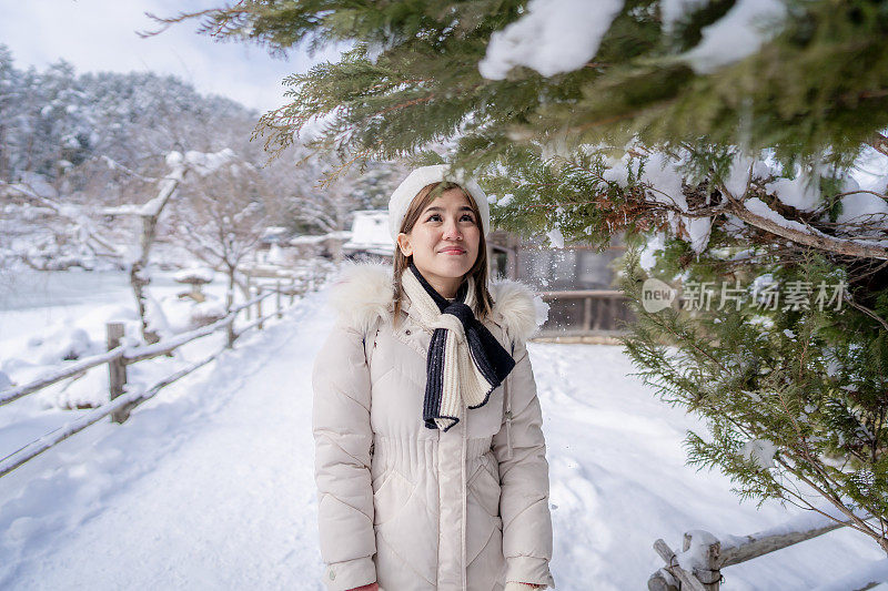 美丽的女子游客享受他们的日本之旅在雪的冬天