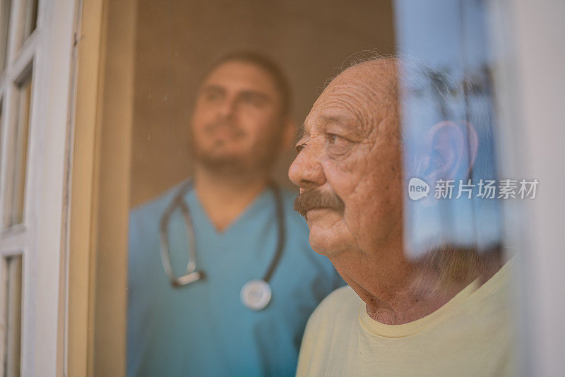 护士和老人在敬老院透过窗户看