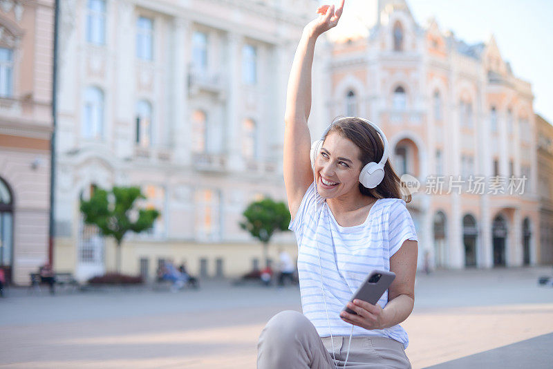 画像一个美丽的年轻女子享受户外和听音乐